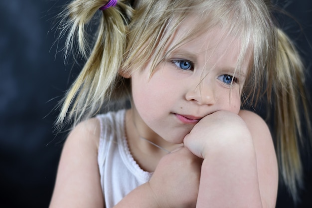 Romantisches Porträt eines kleinen Mädchens auf einem schwarzen Hintergrund