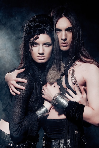 Romantisches Porträt von jungen gotischen Paaren - Mann und Frau über dunklem Hintergrund. Spezielle Tonisierung.