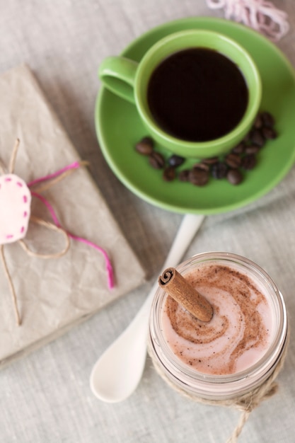 Romantisches reichhaltiges Frühstück: Haferflocken mit Beerenjoghurt und Zimt, schwarzer Kaffee und ein Notizbuch für Vintage-Schallplatten