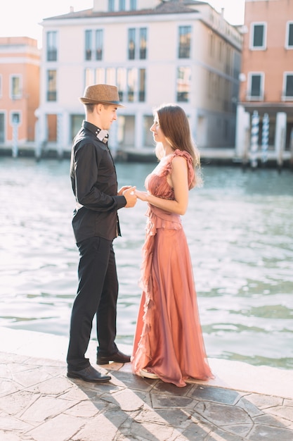 Romantisches schönes Paar in Venedig glücklich zusammen stehend auf dem Hintergrund des venezianischen Kanals und der Gebäude. Italien, Europa.