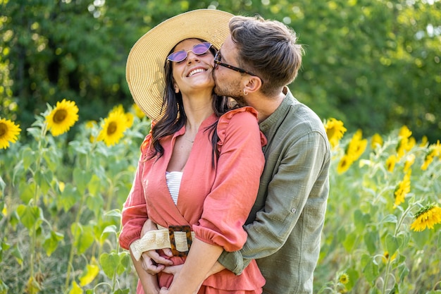 Romantisches verliebtes Paar in einem Sonnenblumenfeld Valentinstag-Konzept