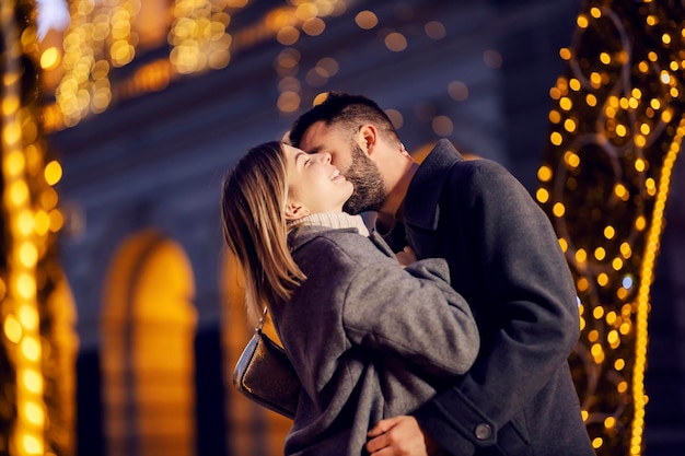 Romantisches Weihnachtspaar küsst sich am Neujahrstag im Freien