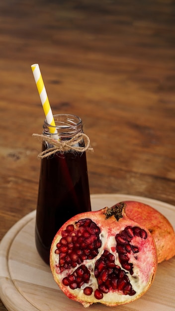 Romãs maduras com suco em fundo de madeira