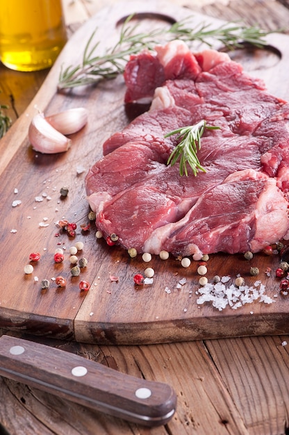 - Romero de carne cruda en rodajas sobre fondo de madera