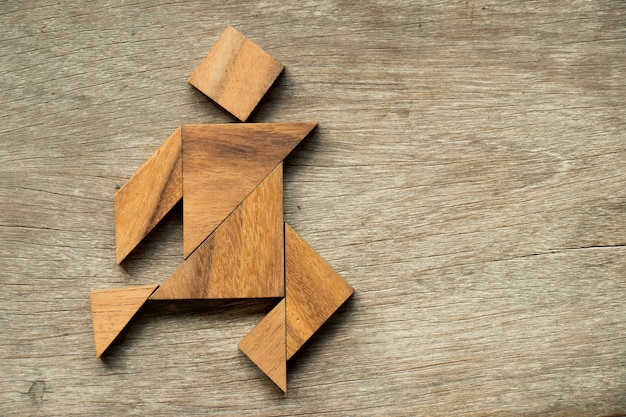 Rompecabezas de madera tangram como hombre corriendo fondo