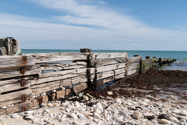 Rompeolas de madera vieja en la playa de arena