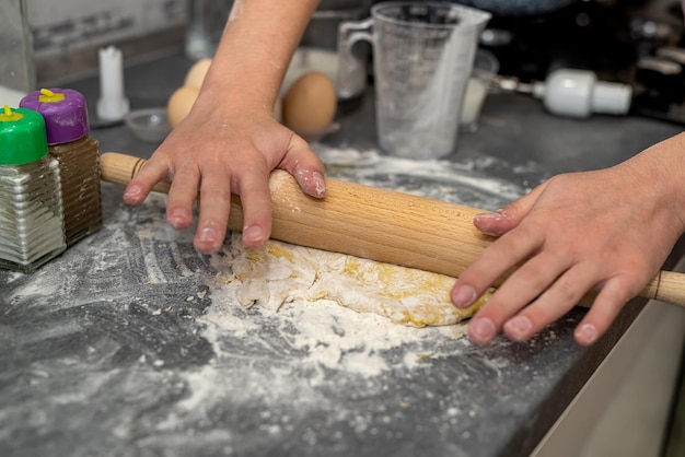 Rompiendo huevos con manos de mujeres en harina para hacer masa para pasteles