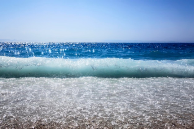 Rompiendo la ola de fondo de verano del océano azul