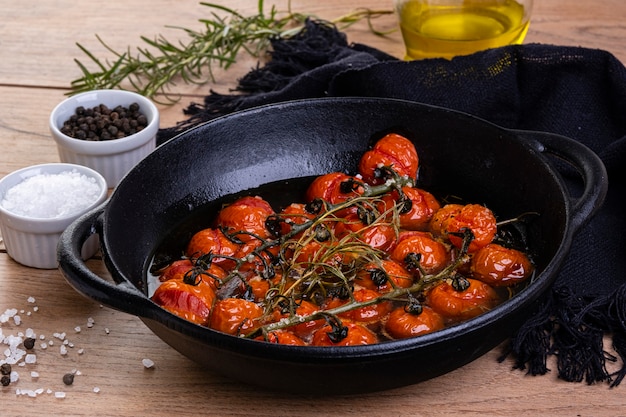 Ron caçarola com tomate confitado na mesa de madeira.