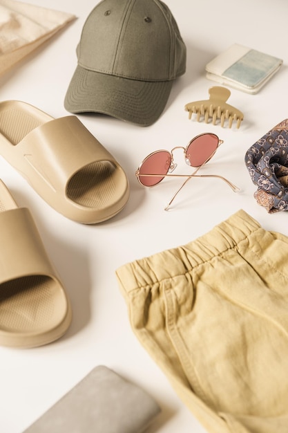 Ropa y accesorios de moda de mujer de color beige polvoriento neutro para vacaciones de verano playa relajarse sobre fondo blanco Concepto de estilo de vida femenino estético