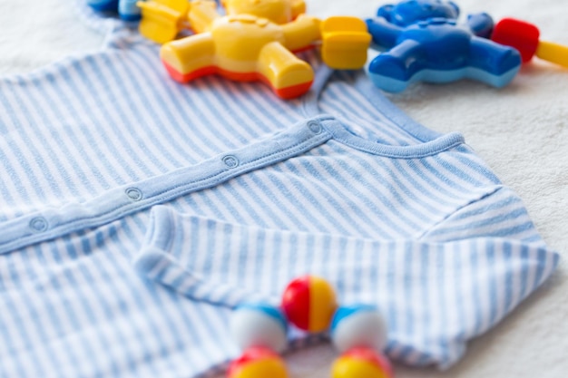 ropa de bebé, infancia y concepto de objeto - cierre de traje azul en toalla para niño recién nacido y sonajero