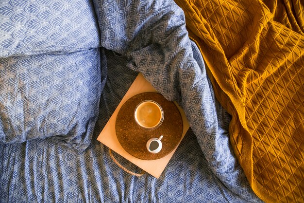 Ropa de cama azul clásica con una bandeja de café y jarra de leche.