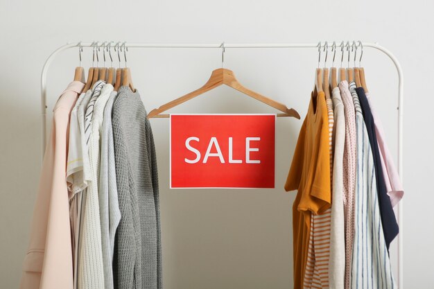 Ropa en el carril y un cartel de venta descuentos de venta final