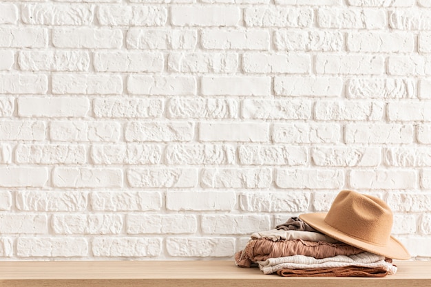 Ropa casual para mujer y sombrero marrón de moda en mesa de madera