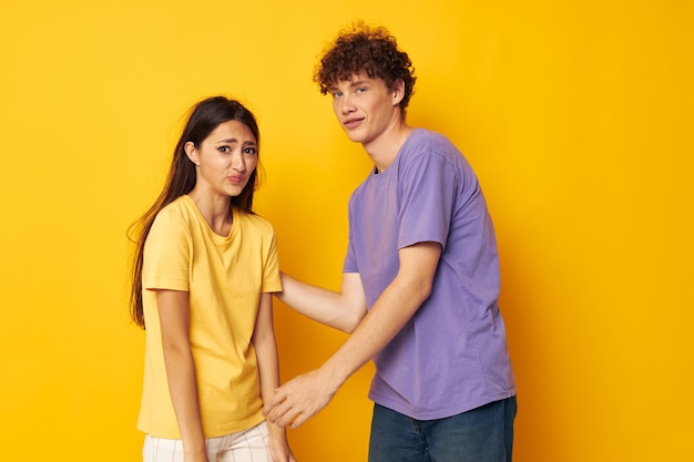 Ropa casual de niño y niña posando emociones travesuras fondo amarillo inalterado