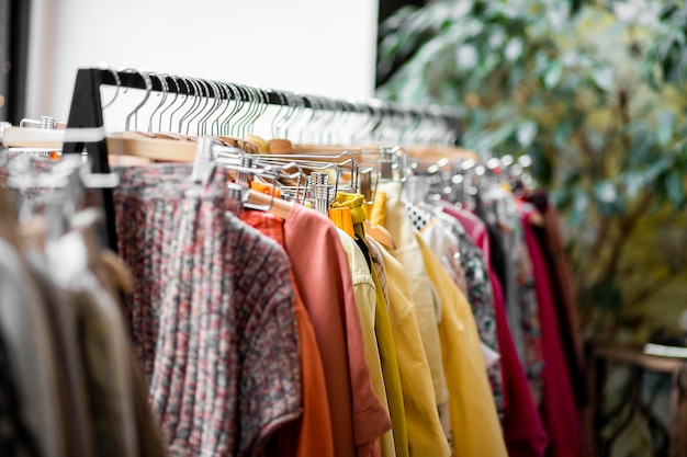 Foto ropa colgada en la boutique de la tienda moderna. ropa en perchas en la tienda. vestidor moderno en