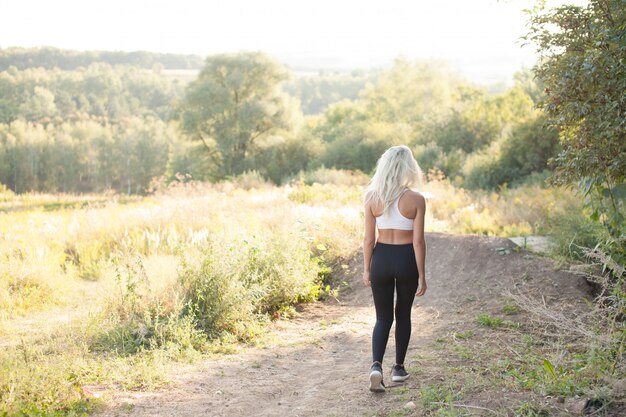 Ropa deportiva de mujer corriendo sobre una colina