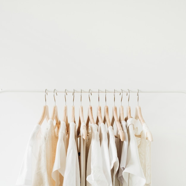 Ropa femenina en percha. Composición de moda mínima en blanco.