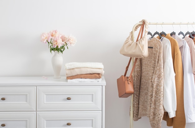 Ropa femenina en perchas en sala blanca