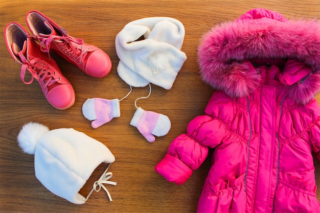 Ropa de invierno para niños: chaqueta rosa cálida, gorro, bufanda, guantes, botas.