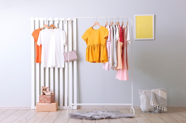 Ropa de moda en un perchero en el interior de una habitación luminosa.