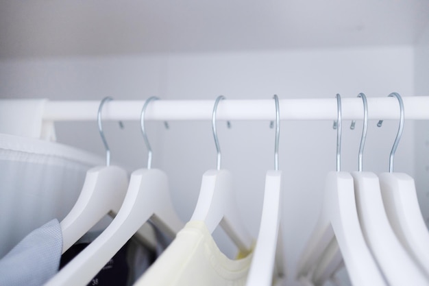 Ropa de mujer colgada en perchas de madera en el armario. Ropa casual de moda. Compras.