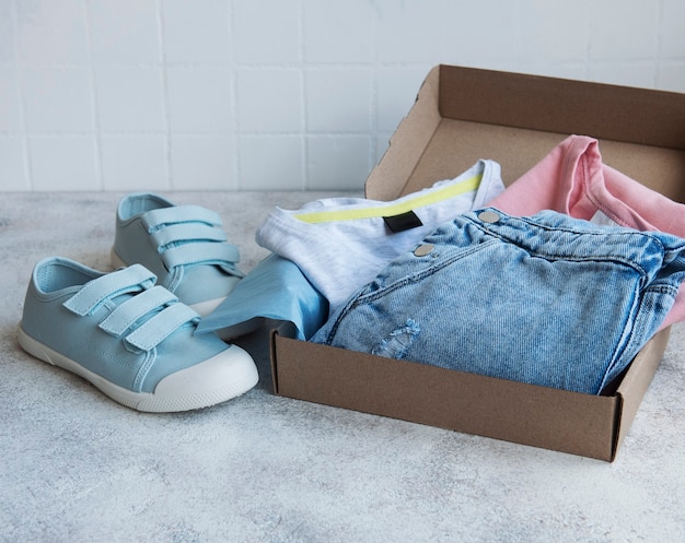 Ropa para niños en una caja de cartón abierta.