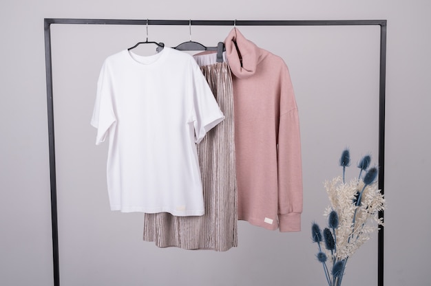 Ropa pastel de moda minimalista para mujer. Camisetas femeninas con estilo, sudadera con capucha, pantalones en percha