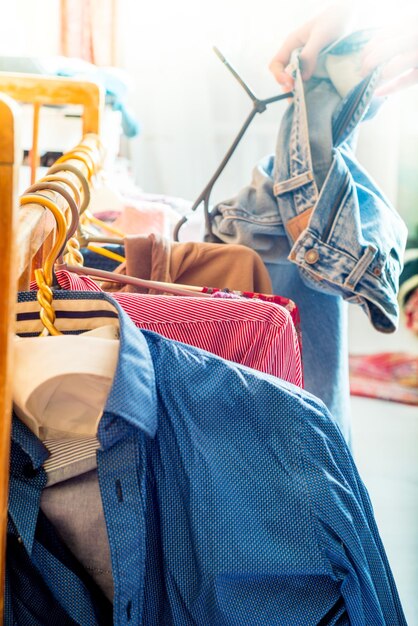 Foto ropa en una percha persona elige jeans entre otras cosas