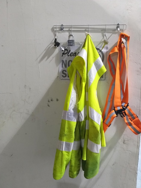 Ropa reflectante colgada contra la pared en un gancho
