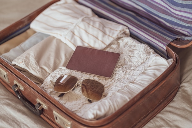 Ropa de verano para mujer cuidadosamente doblada para ser empacada en una maleta. Maleta de viaje preparando.