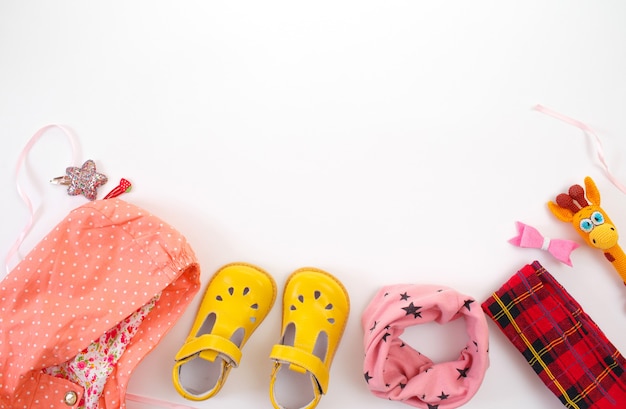 La ropa y los zapatos para niños se presentan en una vista superior de fondo blanco. Espacio para el texto.