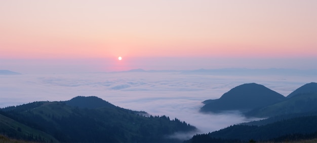 Rosa amanecer sobre las nubes en las montañas