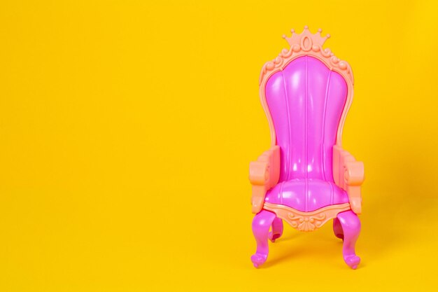 Foto rosa babypuppenstuhl auf gelbem hintergrund mit kopienraum