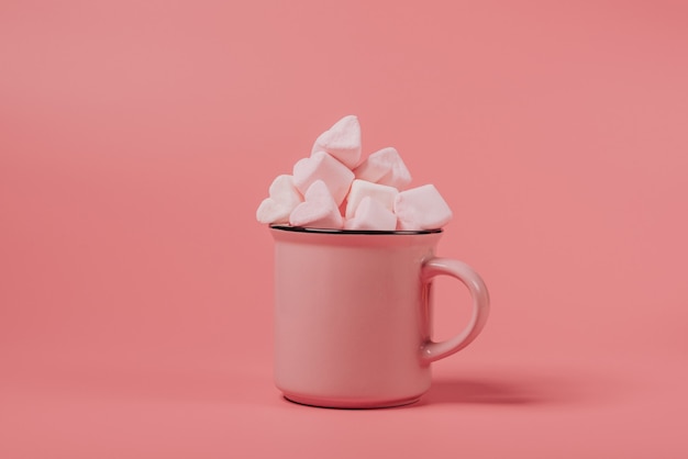 Rosa Becher gefüllt mit Marshmallows in Form von Herzen