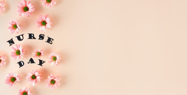 Rosa Chrysanthemen auf pastellrosa Hintergrund und stilvolle Buchstaben-Draufsicht mit Kopienraum floral