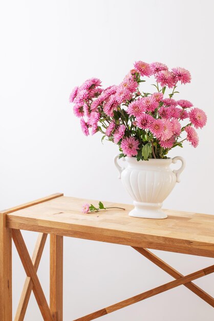 Rosa Chrysanthemen in weißer Vase auf weißem Interieur