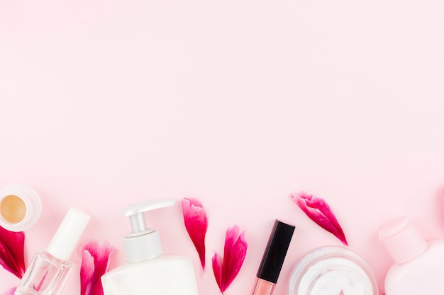 Rosa conjunto de produtos cosméticos e pétalas