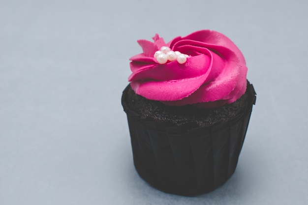 Rosa Cupcake auf grauem Hintergrund