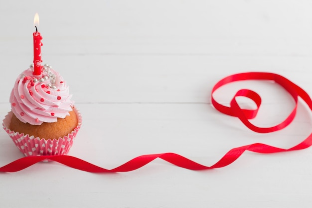 Rosa cupcake en mesa de madera blanca