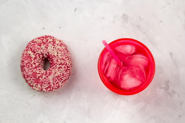 Rosa Donut der Draufsicht und kaltes Getränk