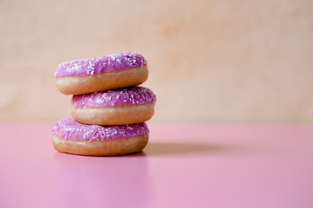 Rosa Donuts in der süßen Glasur auf einem rosa Hintergrund