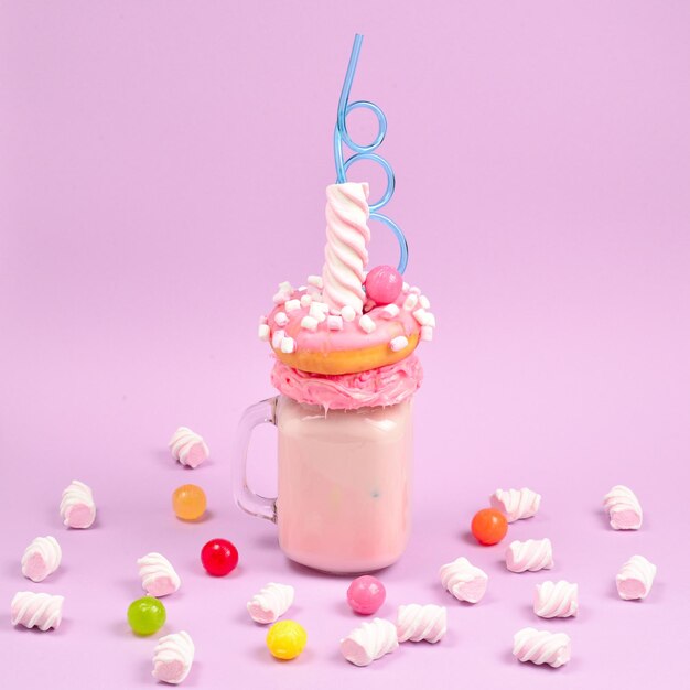 Rosa Erdbeer-Freakshake mit Marshmallow und Süßigkeiten