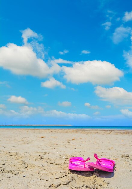 Rosa Flip-Flops auf dem Sand in Sardinien Italien