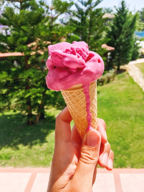 Rosa geschmackvolle Eistüte in der Hand
