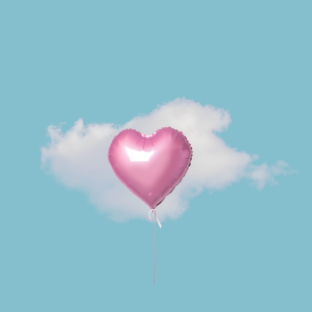 Rosa Herzballon mit weißer Wolke auf blauem Himmel