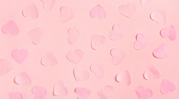 Rosa Herzen aus Papier auf einer rosa Oberfläche