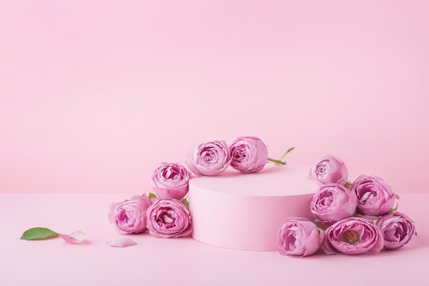 Rosa Hintergrund mit Rosen und Podest für Kosmetik und Accessoires