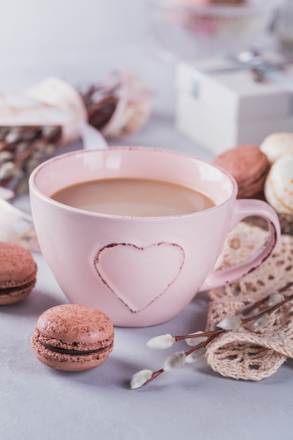 Rosa Kaffeetasse mit süßen französischen Pastellmakronen