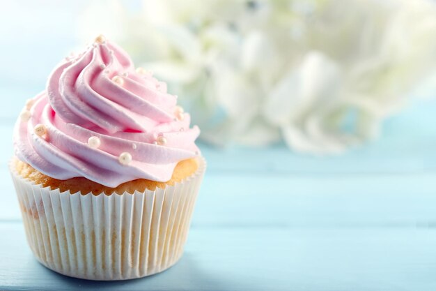 Rosa kleiner Kuchen auf hölzernem Hintergrund